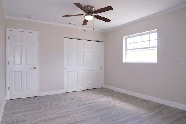 unfurnished bedroom featuring light wood finished floors, visible vents, and crown molding