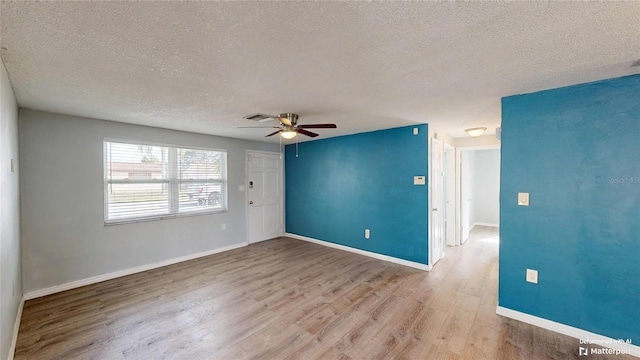 spare room featuring a ceiling fan, wood finished floors, baseboards, and visible vents