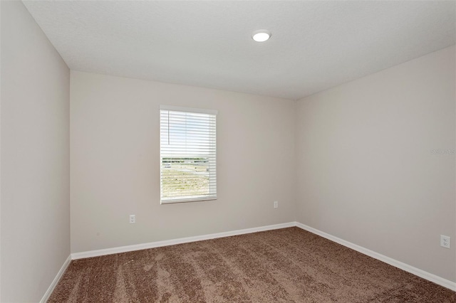 empty room with baseboards and carpet flooring