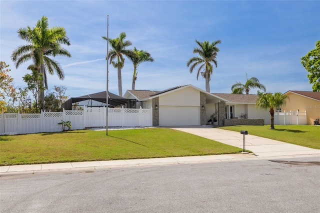 7906 Bayshore Dr, Seminole, FL 33776 - view of front of property with a garage, driveway, fence, and a front lawn