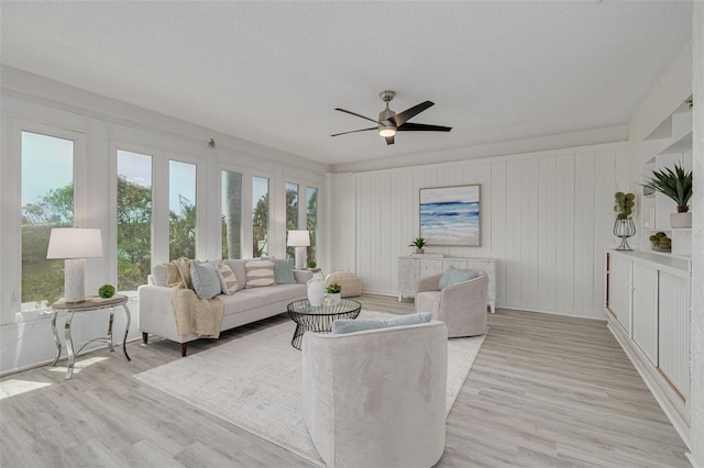 7906 Bayshore Dr, Seminole, FL 33776 - living room featuring light wood-style flooring, a textured ceiling, and ceiling fan