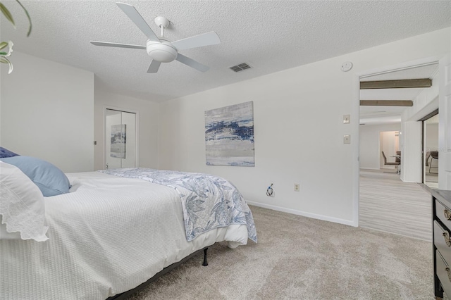 7906 Bayshore Dr, Seminole, FL 33776 - bedroom featuring visible vents, baseboards, a ceiling fan, a textured ceiling, and light colored carpet