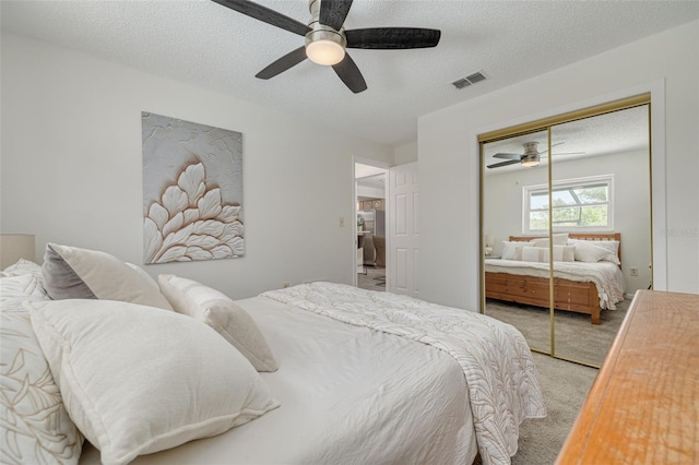 7906 Bayshore Dr, Seminole, FL 33776 - bedroom featuring a closet, light carpet, a textured ceiling, visible vents, and ceiling fan