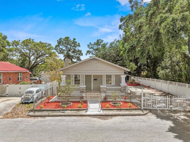 bungalow-style house featuring a gate, a fenced front yard, and a porch