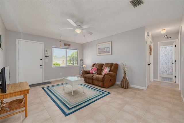 2605 Fulton St SW, Largo, FL 33774 - living room featuring ceiling fan, light tile patterned floors, a textured ceiling, and baseboards