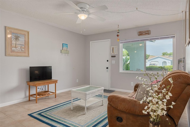 2605 Fulton St SW, Largo, FL 33774 - living room featuring light tile patterned flooring, ceiling fan, a textured ceiling, and baseboards