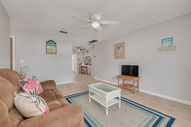 2605 Fulton St SW, Largo, FL 33774 - living room featuring a ceiling fan, light tile patterned floors, a textured ceiling, and baseboards