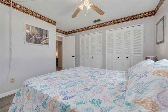 2605 Fulton St SW, Largo, FL 33774 - bedroom featuring wood finished floors, two closets, baseboards, and ceiling fan
