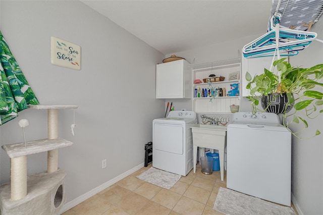 2605 Fulton St SW, Largo, FL 33774 - laundry room featuring separate washer and dryer, cabinet space, light tile patterned floors, and baseboards
