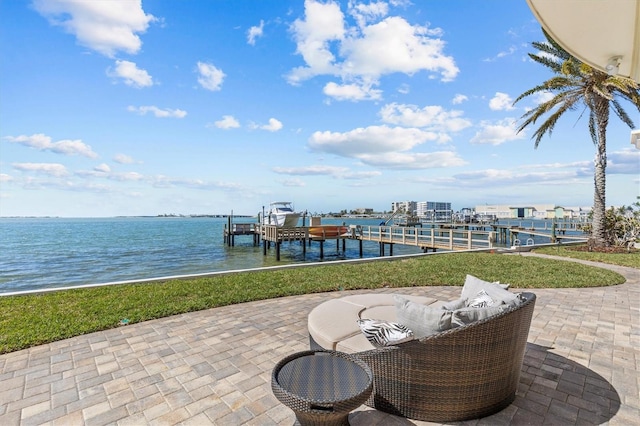 view of patio / terrace featuring boat lift, a dock, and a water view