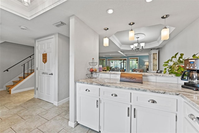 170 Ingrid Pl, Oldsmar, FL 34677 - kitchen featuring decorative light fixtures, white cabinets, ornamental molding, and a tray ceiling