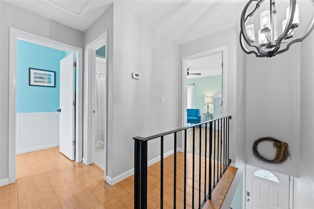 170 Ingrid Pl, Oldsmar, FL 34677 - hall featuring light wood-style flooring, baseboards, a notable chandelier, and an upstairs landing