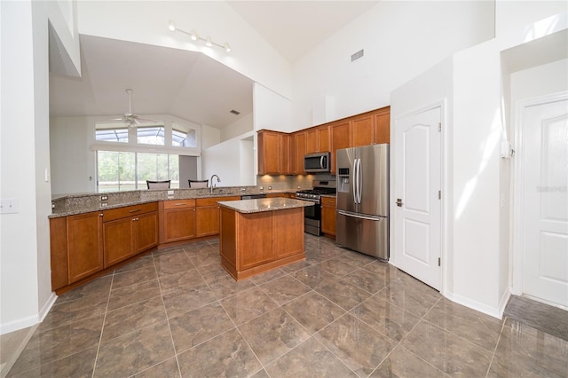 5331 Villagebrook Dr, Wesley Chapel, FL 33544 - kitchen featuring appliances with stainless steel finishes, a sink, vaulted ceiling, brown cabinetry, and ceiling fan