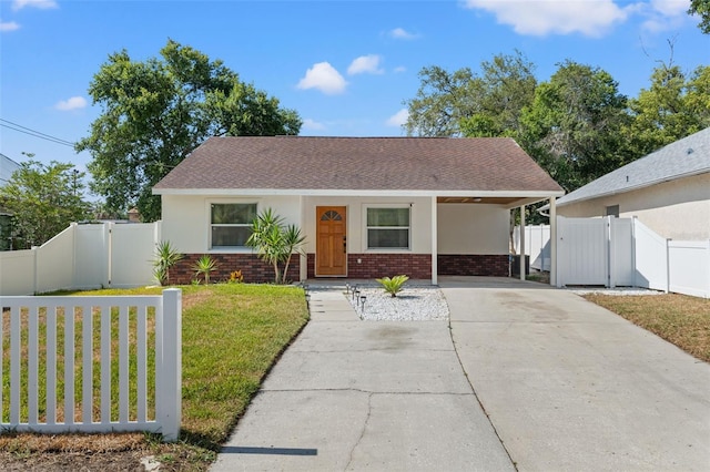 439 E Boyer St, Tarpon Springs, FL 34689 - view of front of house featuring a gate, a front lawn, brick siding, and driveway