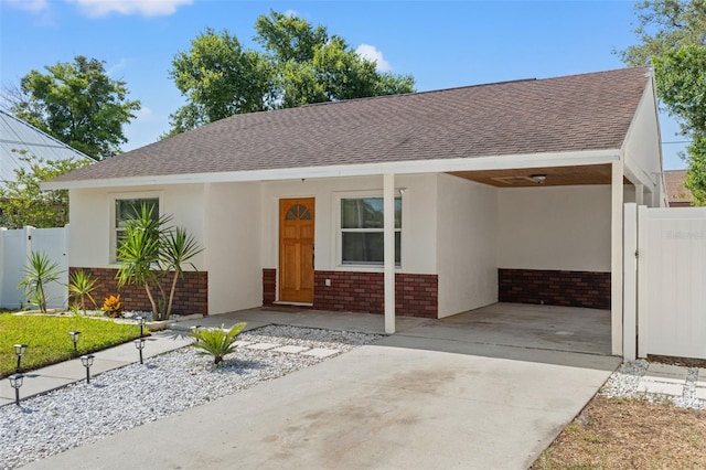 439 E Boyer St, Tarpon Springs, FL 34689 - ranch-style home featuring a carport, a shingled roof, concrete driveway, and brick siding