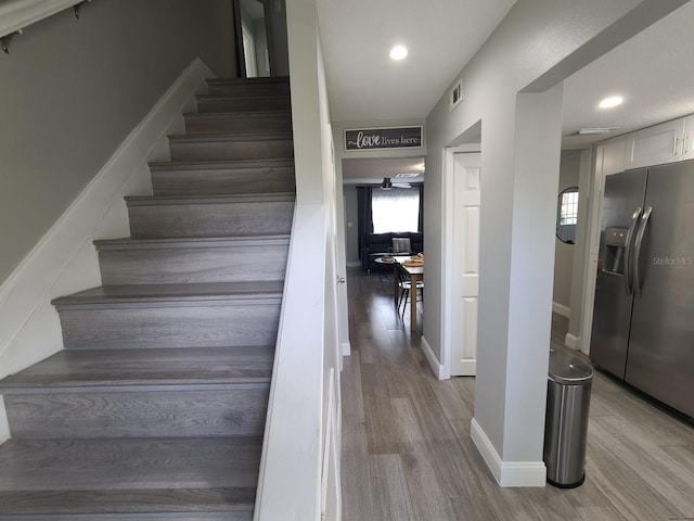 stairs featuring recessed lighting, visible vents, baseboards, and wood finished floors