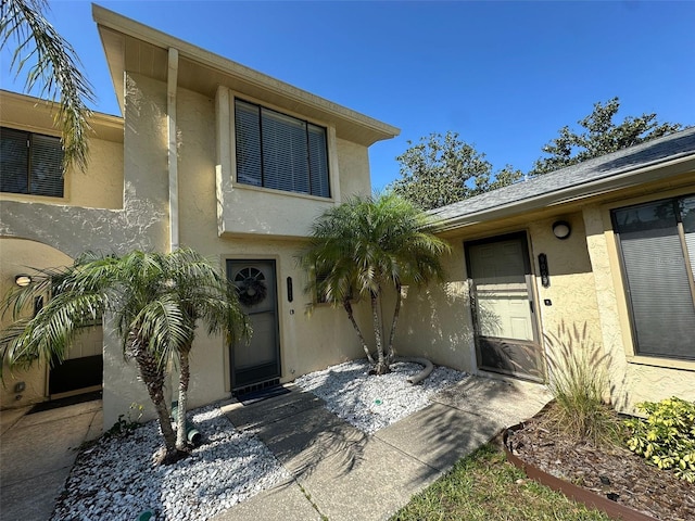 doorway to property featuring stucco siding