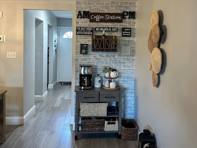 hallway featuring wood finished floors and baseboards