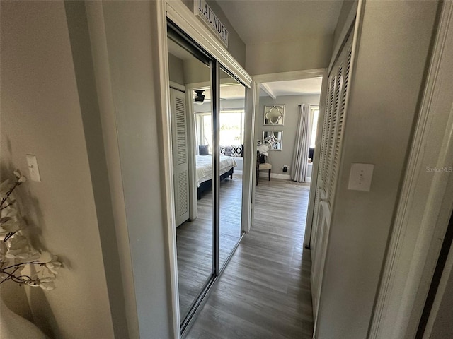 hallway featuring wood finished floors, baseboards, and visible vents