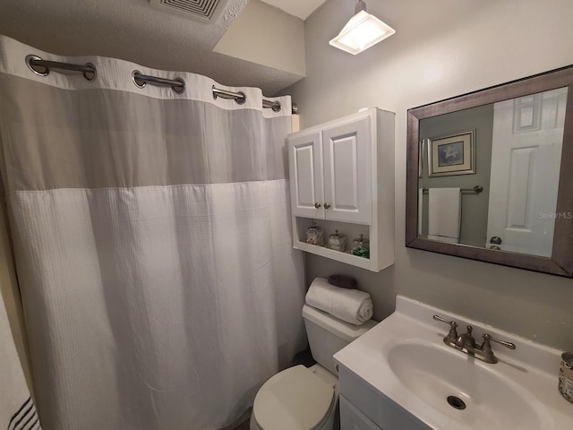 bathroom with toilet, vanity, visible vents, and a shower with curtain