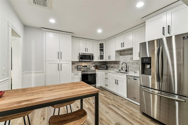 610 N Woodlynne Ave, Tampa, FL 33609 - kitchen featuring light countertops, a sink, appliances with stainless steel finishes, light wood-style flooring, and visible vents