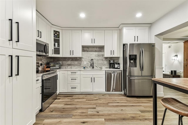 610 N Woodlynne Ave, Tampa, FL 33609 - kitchen with light countertops, a sink, stainless steel appliances, and light wood finished floors