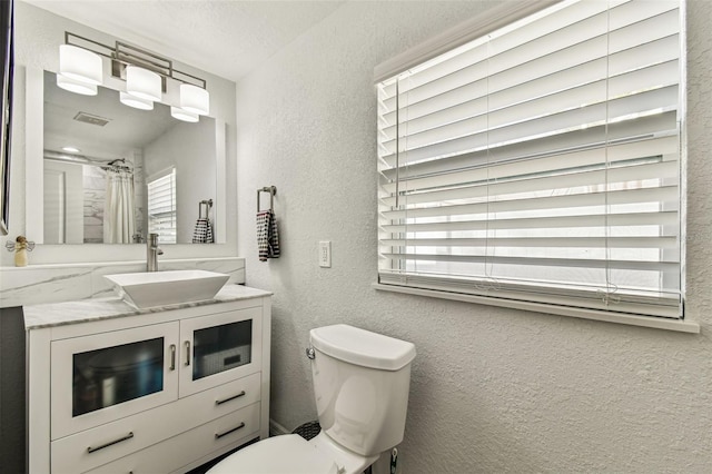610 N Woodlynne Ave, Tampa, FL 33609 - full bathroom with visible vents, a textured wall, toilet, and vanity