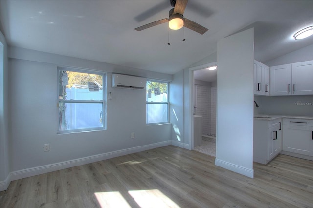610 N Woodlynne Ave, Tampa, FL 33609 - interior space featuring ensuite bathroom, light wood finished floors, baseboards, a wall unit AC, and vaulted ceiling