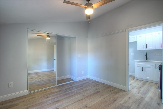 610 N Woodlynne Ave, Tampa, FL 33609 - spare room featuring vaulted ceiling, a sink, light wood finished floors, baseboards, and ceiling fan