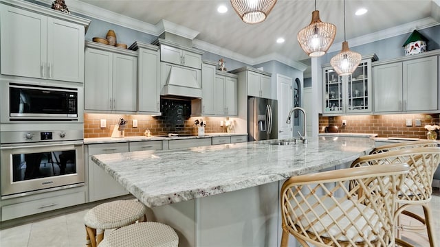 16612 5th Ave E, Bradenton, FL 34212 - kitchen featuring stainless steel appliances, backsplash, a breakfast bar area, glass insert cabinets, and light stone counters