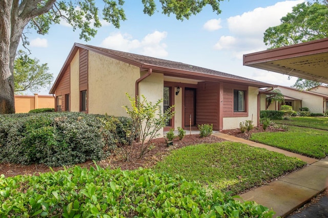 view of front facade featuring a front yard and stucco siding