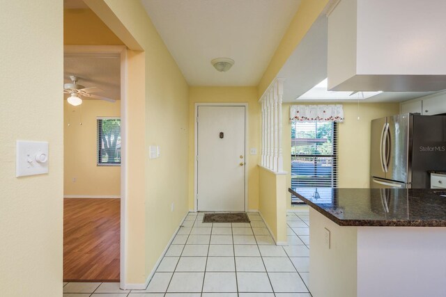 entrance foyer featuring baseboards, ceiling fan, and light tile patterned floors