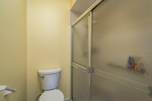 full bath with toilet and a shower stall