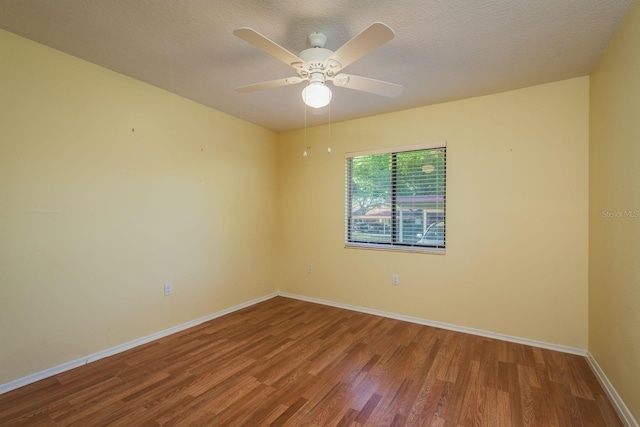 empty room featuring baseboards, wood finished floors, ceiling fan, and a textured ceiling