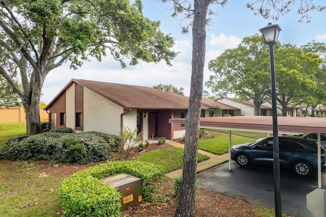 view of front facade with stucco siding and covered parking