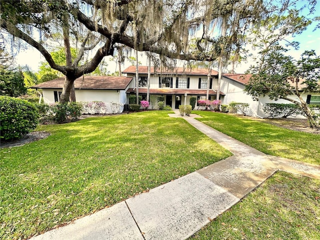 traditional-style home featuring stucco siding and a front lawn