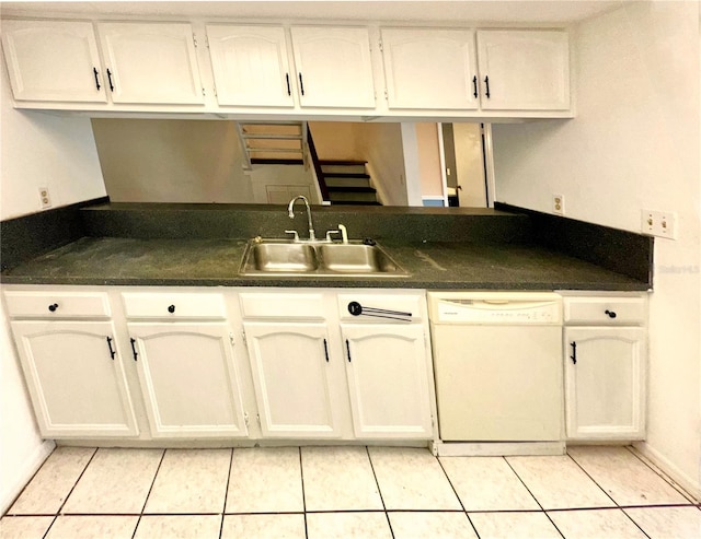 kitchen featuring a sink, light tile patterned flooring, dark countertops, and white dishwasher