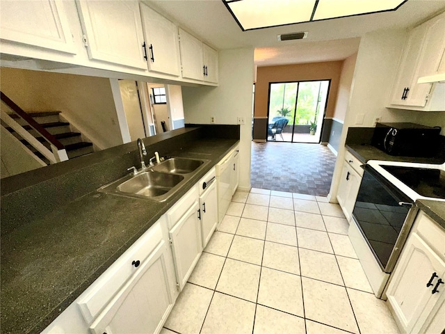 kitchen featuring range, a sink, dark countertops, dishwasher, and black microwave