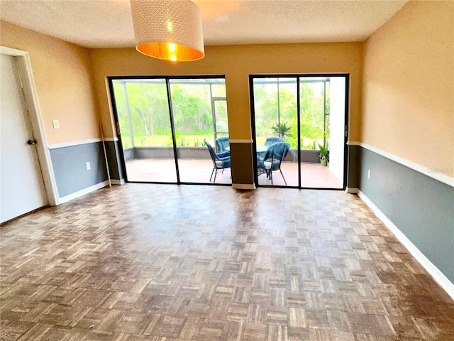 unfurnished room featuring a textured ceiling and baseboards