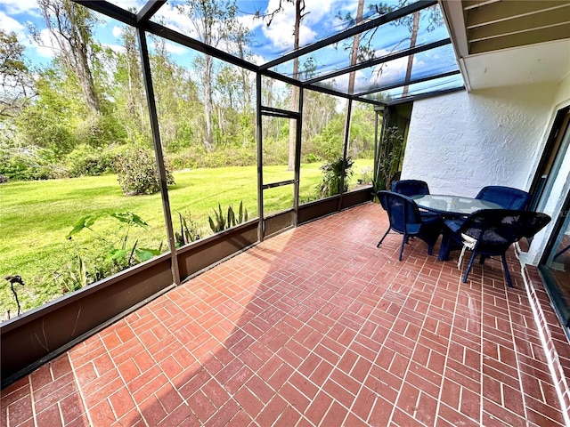 sunroom with outdoor dining space and a healthy amount of sunlight