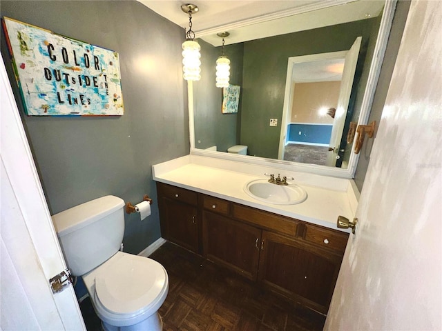 half bathroom with toilet, baseboards, and vanity