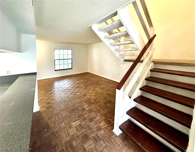 staircase with baseboards and a textured ceiling