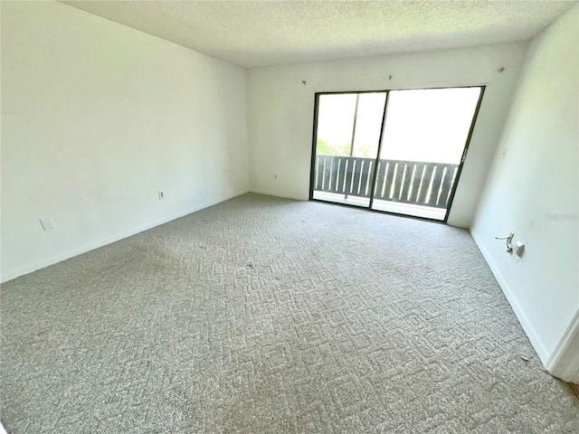 carpeted empty room featuring a textured ceiling and baseboards