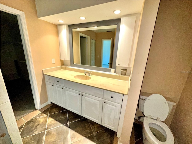 bathroom featuring toilet, tile patterned floors, vanity, and recessed lighting