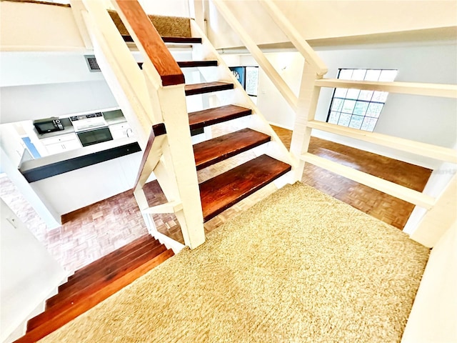 stairs featuring visible vents and parquet floors