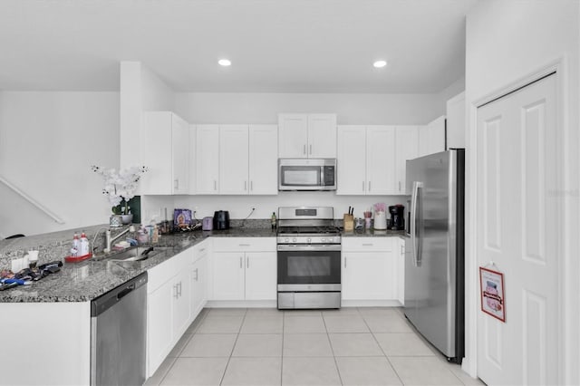 8299 Crescent Oaks Dr, New Port Richey, FL 34655 - kitchen with white cabinetry, light tile patterned floors, and appliances with stainless steel finishes