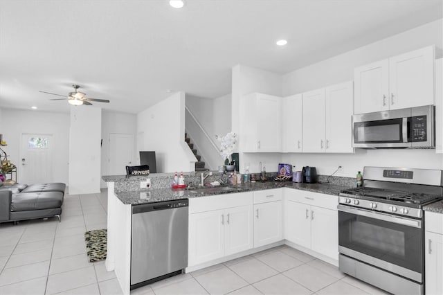 8299 Crescent Oaks Dr, New Port Richey, FL 34655 - kitchen with a sink, a peninsula, open floor plan, stainless steel appliances, and white cabinets