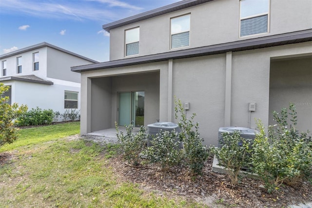 8299 Crescent Oaks Dr, New Port Richey, FL 34655 - rear view of property featuring cooling unit, stucco siding, and a yard