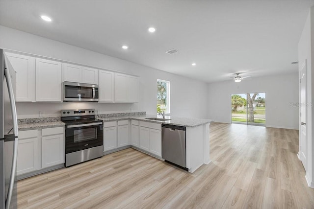 385 Begonia Ct, Poinciana, FL 34759 - kitchen featuring stainless steel appliances, healthy amount of natural light, white cabinetry, and recessed lighting