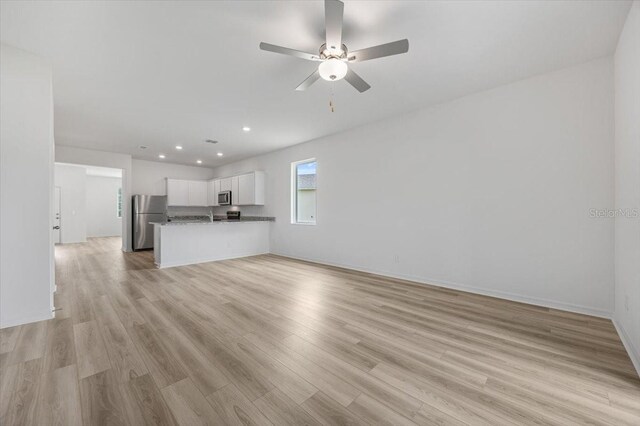 385 Begonia Ct, Poinciana, FL 34759 - unfurnished living room with light wood-style flooring, ceiling fan, recessed lighting, and baseboards